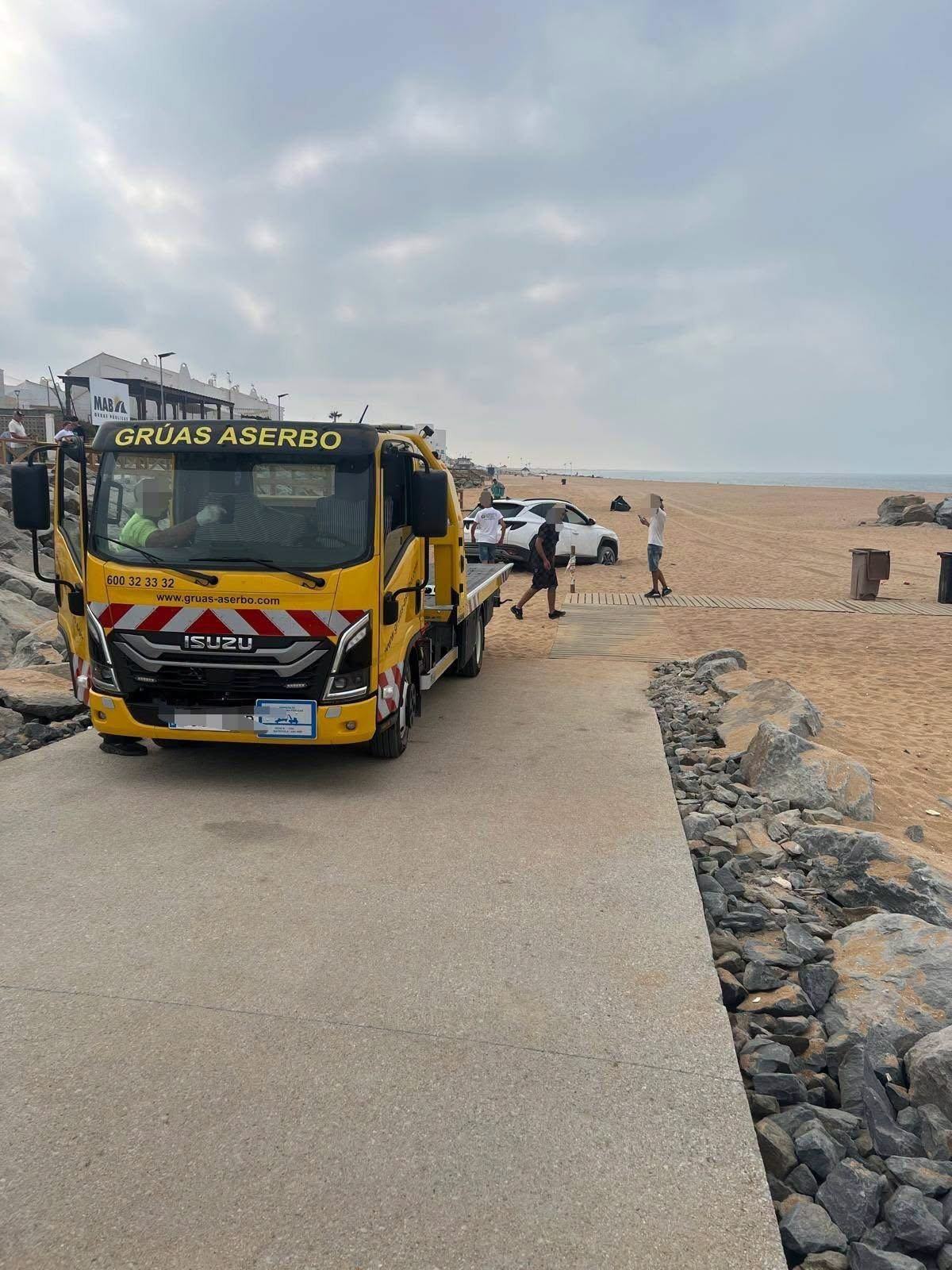 Un conductor accede con su vehículo hasta la arena de Matalascañas tras entrar por el nuevo paseo marítimo